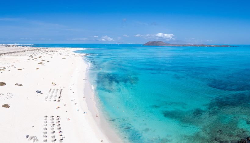 Luftaufnahme der Playa de Corralejo auf Fuerteventura mit hellem Sandstrand und türkisfarbenem Meer