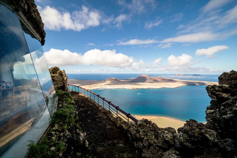 Mirador del Río Aussichtspunkt – berühmter Lanzarote-Ausblick über La Graciosa Aussicht vom Mirador del Río mit Glasfassade und Blick über die Insel La Graciosa und den tiefblauen Atlantik auf Lanzarote.