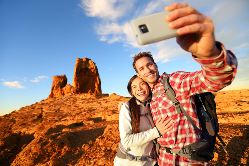 Selfie am Roque Nublo – Gran Canarias Wahrzeichen erleben Ein Paar macht ein Selfie beim Wandern am Roque Nublo auf Gran Canaria. Die imposante Felsformation und das warme Sonnenlicht schaffen eine spektakuläre Kulisse für unvergessliche Urlaubsmomente.