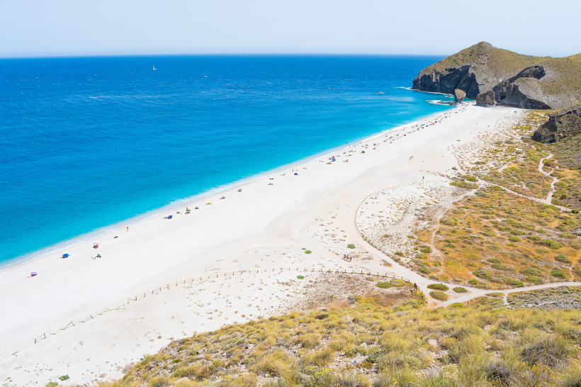 Blick auf die Playa de los Muertos bei Almería mit langem Sandstrand, türkisblauem Meer und Felsenküste