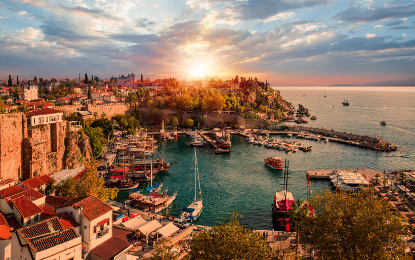 Historischer Hafen von Antalya im warmen Abendlicht mit Booten und Altstadtblick – stimmungsvolles Motiv für den Antalya Urlaub.