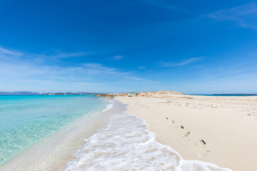 Sandstrand auf Formentera mit türkisfarbenem Meer und blauem Himmel