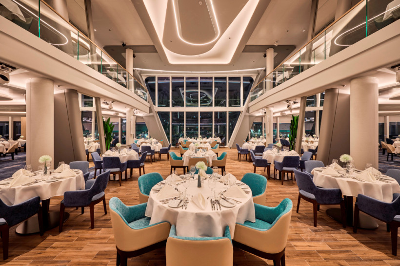 Heck-Bereich des Atlantik Restaurants an Bord der Mein Schiff Relax Mein Schiff Relax: Heck-Bereich des Atlantik Restaurants mit gedeckten Tischen, Panoramafenstern und Sitzgruppen