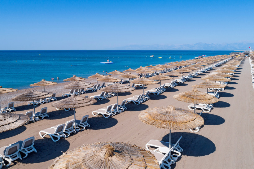 Sommer in Belek: Endlose Strände Breiter Sandstrand in Belek mit Sonnenschirmen und Liegen am türkisblauen Meer – typisches Sommerbild der Türkischen Riviera.