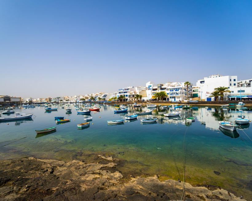 Charco de San Ginés in Arrecife – malerischer Naturhafen mit Fischerbooten auf Lanzarote Malerischer Blick auf den Charco de San Ginés in Arrecife auf Lanzarote mit traditionellen Fischerbooten im ruhigen Hafenbecken.