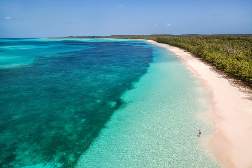 Küstenabschnitt auf Cat Island mit Sandstrand und türkisfarbenem Wasser Luftaufnahme eines langen Sandstrandes mit türkisblauem Meer und Küstenvegetation auf Cat Island