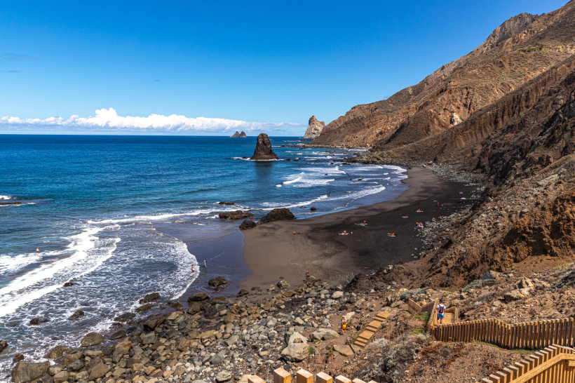 Playa de Benijo – Schwarzer Vulkanstrand auf Teneriffa Schwarzer Sandstrand Playa de Benijo auf Teneriffa, umgeben von Felsen, mit Blick auf den Atlantik und einzelne Besucher am Strand