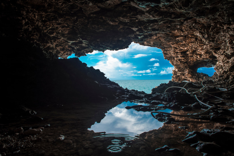 Animal Flower Cave auf Barbados mit Felsöffnung zum Meer und reflektierendem Wasserbecken.