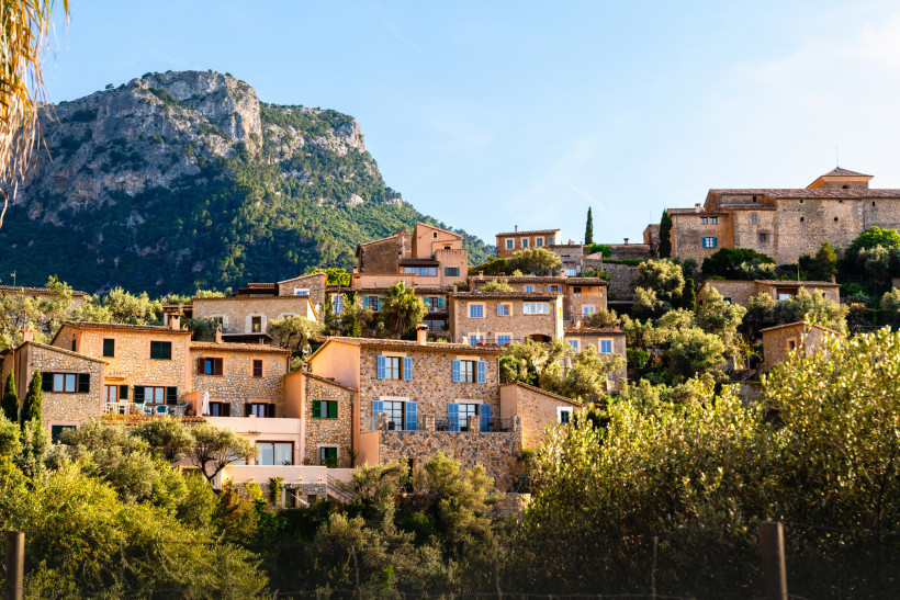 Deià, Mallorca Blick auf das Bergdorf Deià auf Mallorca mit traditionellen Steinhäusern, Olivenhainen und der Serra de Tramuntana im Hintergrund
