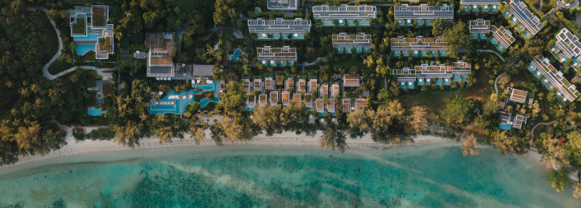 Thailand - Phuket Luftaufnahme eines Resorts auf Phuket. Die Anlage liegt direkt am türkisfarbenen Meer, mit vielen Villen, Pools und tropischer Vegetation. Eine lange Strandlinie zieht sich entlang der gesamten Anlage.