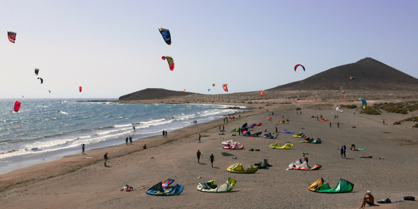 Kitesurfer am Strand von El Médano mit Montaña Roja im Hintergrund auf Teneriffa