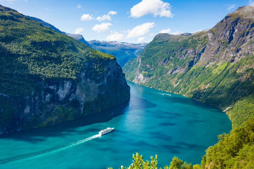 Kreuzfahrtschiff auf einem norwegischen Fjord Kreuzfahrtschiff im norwegischen Fjord zwischen steilen, grünen Bergen