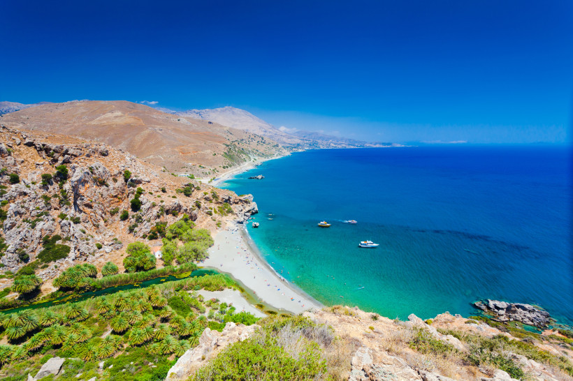 Panoramablick auf den Preveli-Palmenstrand mit Palmenhain, Flussmündung, Sandstrand und türkisblauem Meer