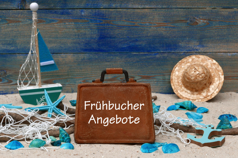 Frühbucher Lanzarote – Günstige Urlaubsangebote für die Kanaren Holzkoffer mit Schrift „Frühbucher Angebote“ im Strandsetting – Frühbucher Lanzarote