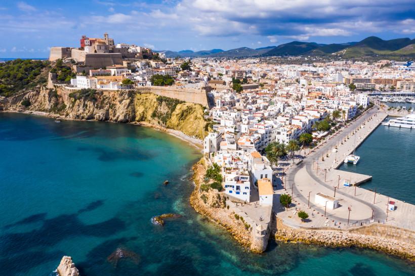 Altstadt von Eivissa mit Festung oberhalb der Küste und Hafenanlage Blick auf die Altstadt von Eivissa mit Festungsmauern, Hafenpromenade und türkisblauem Meer