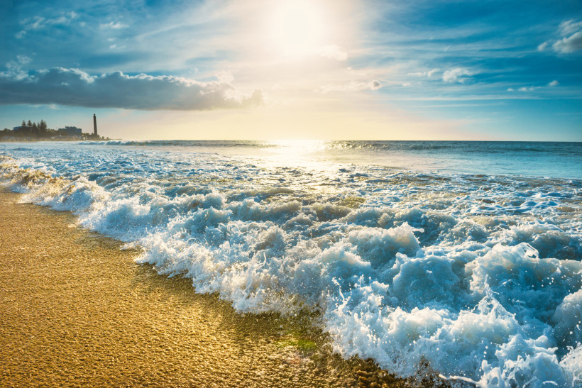 Sonnenuntergang am Strand von Maspalomas Goldene Abendstimmung mit sanften Wellen am Strand von Maspalomas auf Gran Canaria – im Hintergrund der berühmte Leuchtturm, ein Highlight bei jedem Spaziergang an der Promenade.