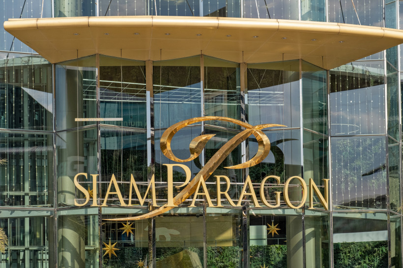 Siam Paragon Bangkok – Luxus-Shopping und Lifestyle im Herzen der Stadt Eingang des Siam Paragon Einkaufszentrums in Bangkok mit goldenem Logo auf Glasfassade