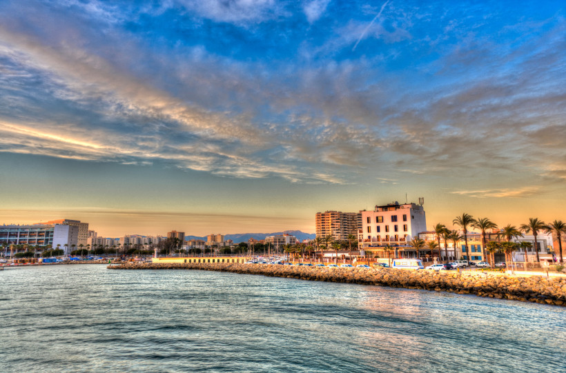 Küstenansicht von Portixol in Palma de Mallorca mit Promenade, Gebäuden und Meer bei Abendlicht