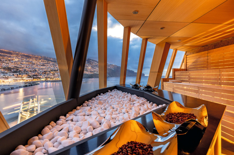 Biosauna auf Mein Schiff 7 mit Blick durch große Fenster auf Küstenstadt und Meer