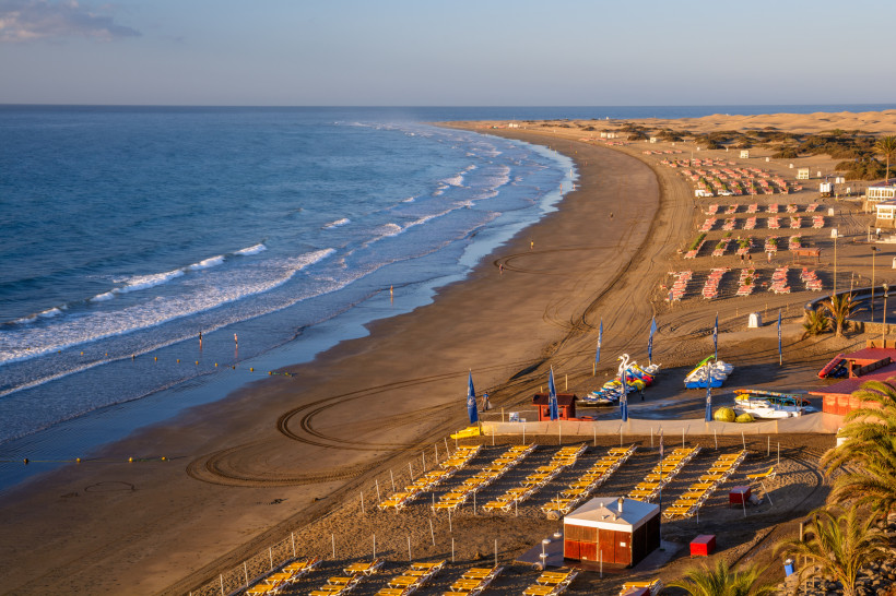 Playa del Ingles Strand mit Dünen und Sonnenliegen – Süden Gran Canarias Langer Sandstrand Playa del Ingles auf Gran Canaria mit Sonnenliegen, Atlantikküste und Blick auf die Dünen im Süden der Insel