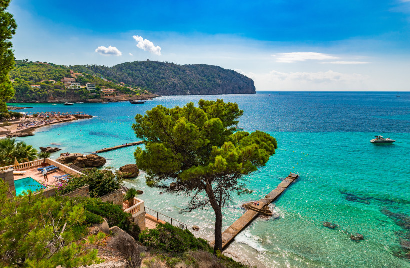 Hotelterrasse mit Pool und Blick über die türkisfarbene Bucht von Camp de Mar auf Mallorca