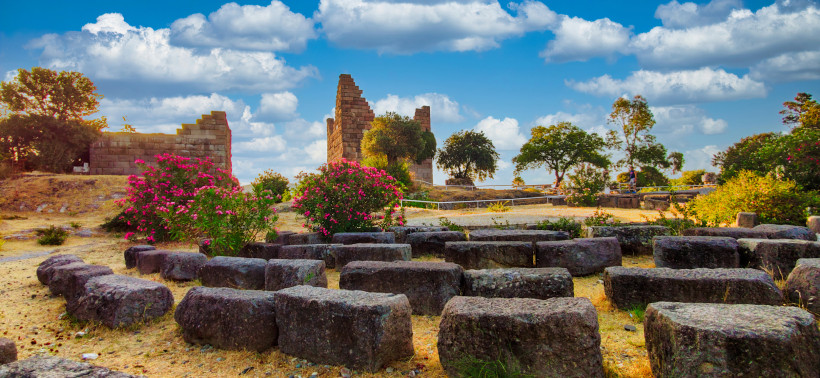 Antike Steinruinen und Sitzreihen von Halikarnassos in Bodrum mit blühenden Oleanderbüschen und Stadtmauerresten