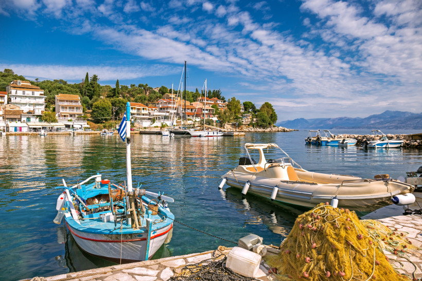 Hafen von Kassiopi mit Fischerbooten, Segelyachten und typischen Häusern am Wasser auf Korfu