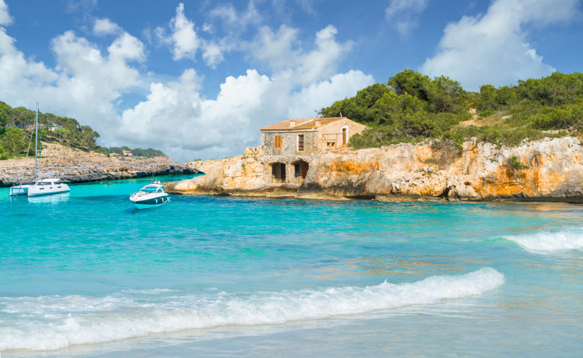 Kleine geschützte Bucht mit klarem, türkisfarbenem Wasser und Felsen bei Cala d’Or auf Mallorca – ideal für entspannte Badetage zu zweit