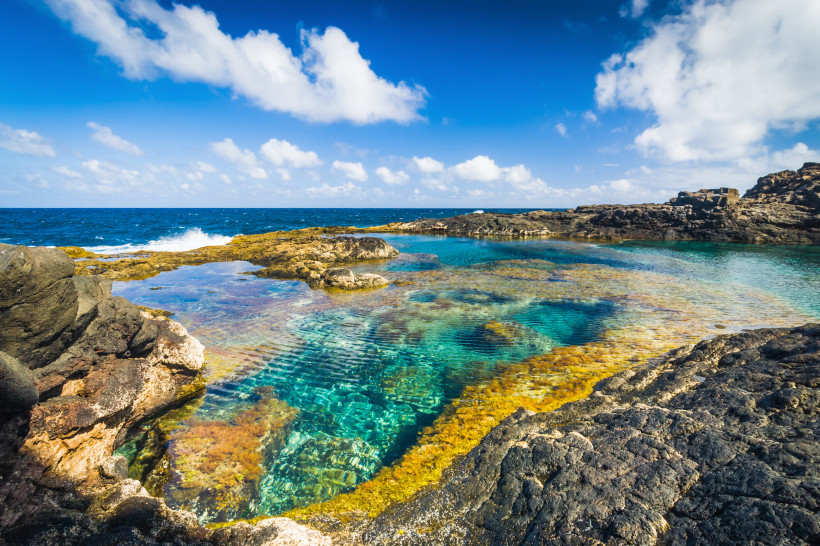 Natürliche Meerwasserpools Los Charcones auf Lanzarote mit türkisfarbenem, klarem Wasser und vulkanischen Felsen an der Atlantikküste