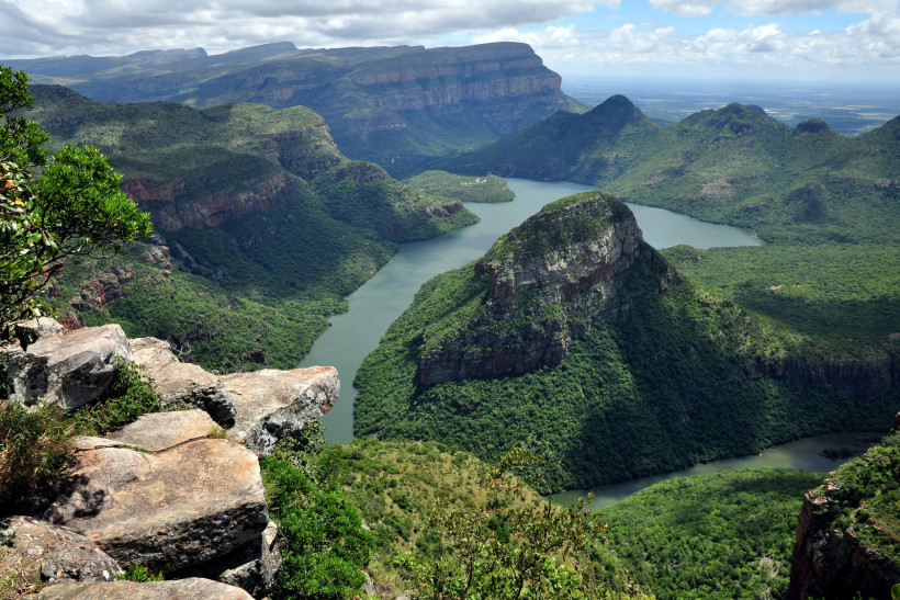 Blick über die Drakensberge mit tief eingeschnittenem Flusstal zwischen grünen Berghängen