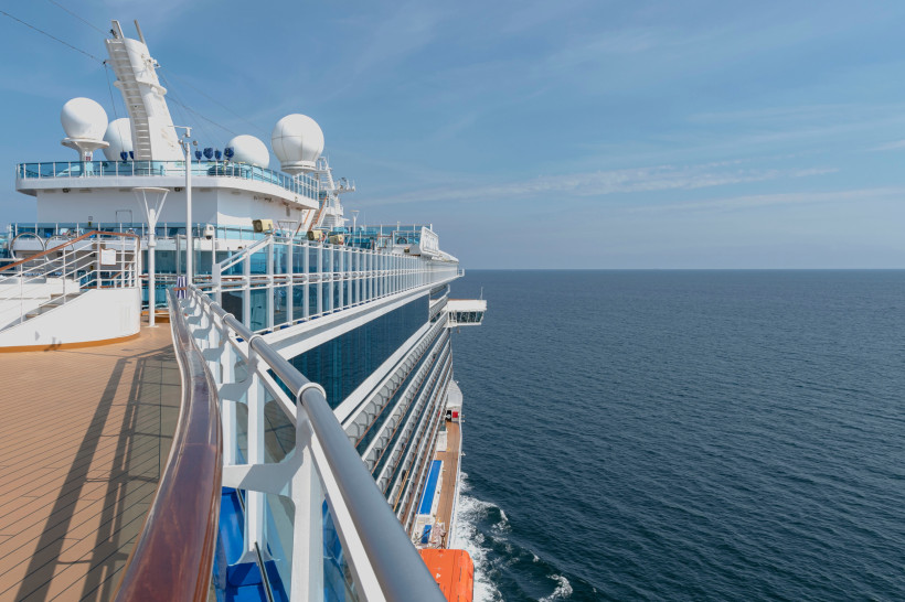 Deck eines Kreuzfahrtschiffs mit Reling und Blick auf das offene Meer
