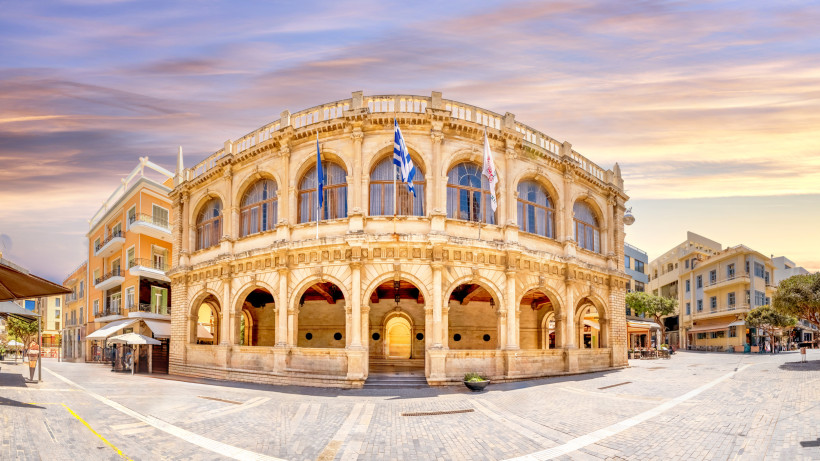 Loggia in der Altstadt von Heraklion mit Arkaden und Flaggen am Platz