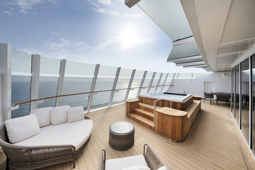 MSC World Europa: Yacht Club Owner’s Suite mit Whirlpoolbad auf der privaten Terrasse Terrasse der Yacht Club Owner’s Suite auf der MSC World Europa mit Whirlpool und Sitzmöbeln, Blick aufs Meer