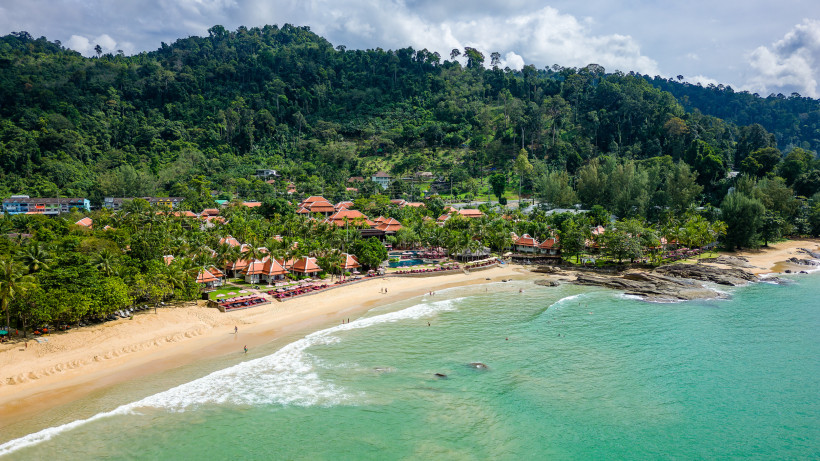 Khao Lak Strandpanorama – tropische Küste und Resorts im Grünen Panoramablick auf den Strand von Khao Lak mit vorgelagerten Resorts, grünen Hügeln und ruhigem Meer.