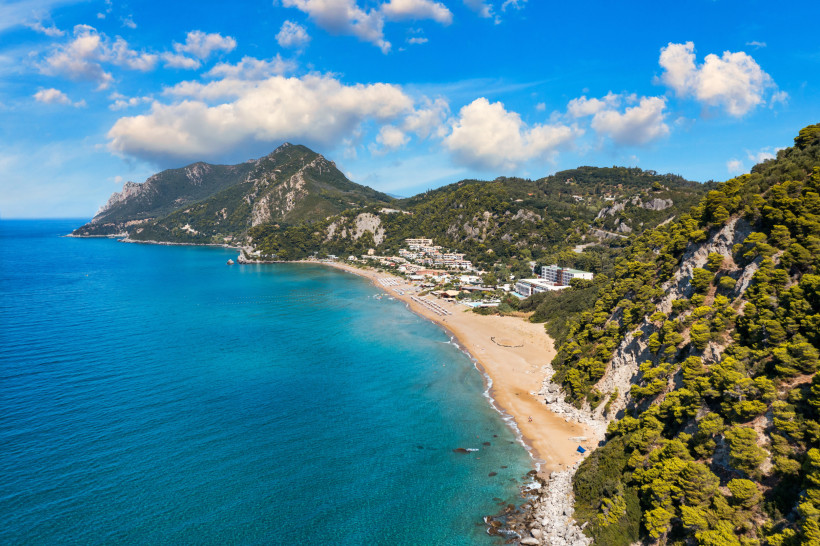 Luftaufnahme vom Glyfada Beach auf Korfu mit langem Sandstrand und grün bewachsenen Bergen
