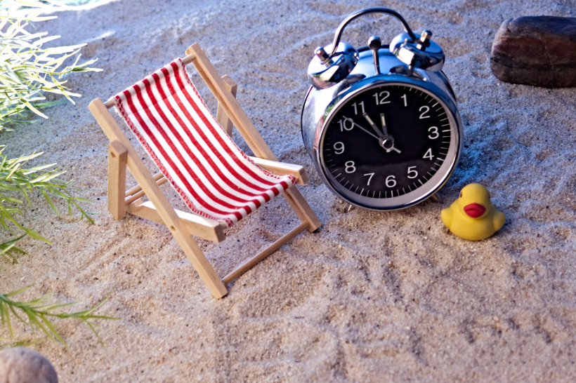 Last Minute Lanzarote – Spontaner Urlaub auf den Kanaren Mini-Liegestuhl und Wecker im Sand – Symbolbild für Last Minute Lanzarote Angebote
