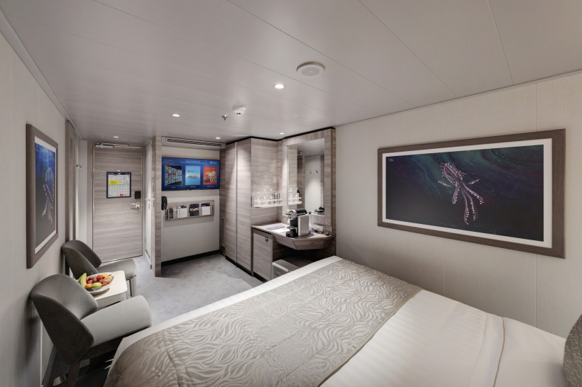 MSC Euribia, MSC Yacht Club Interior Suite (YIN) Schlafbereich einer MSC Euribia Yacht Club Interior Suite mit Doppelbett, Sessel und Arbeitsbereich